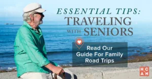 Older man in a hat enjoying a scenic ocean view, symbolizing relaxing and safe travel with seniors during family road trips